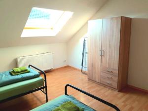 a bedroom with a bed and a cabinet and a skylight at Seyfarthrooms - Großröhrsdorf 2 - zentrale Lage, stilvolle Einrichtung, Blick in den Garten in Großröhrsdorf