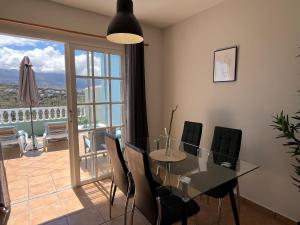 een eetkamer met een glazen tafel en stoelen bij Vista Hermosa 2 in La Esquinita