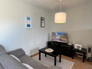 een woonkamer met een bank en een tv bij Vista Hermosa 2 in La Esquinita