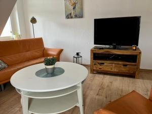 a living room with a white table and a television at Ferienwohnung für 5 Personen in Dresden