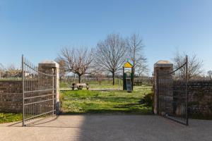 otwarta brama w parku z ławką parkową w obiekcie Agriturismo Mulino Delle Tolle w mieście Bagnário Arsa