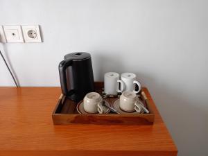a coffee maker and cups on a wooden table at Ronta Bungalows in Legian