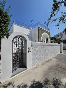a white fence with a gate in front of a house at Villa Dafne in Forio d'Ischia