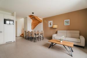 a living room with a couch and a table at Gites des Pierres Sonnantes in Saint-Cast-le-Guildo