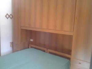 a bedroom with a bed and wooden cabinets at Hotel Rustichello in Marina di Campo