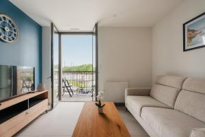 a living room with a couch and a tv at Gites des Pierres Sonnantes in Saint-Cast-le-Guildo