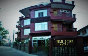a tall building with a sign in front of it at Inle Star Hotel in Nyaungshwe Township