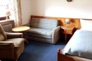 a hotel room with a couch and a chair at Geräumige Ferienwohnung inmitten der Natur in Bischofsgrün