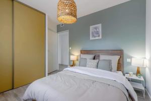 a bedroom with a large bed and a chandelier at Clair Jeanne - 900m plage - Parking in Notre-Dame-de-Monts