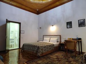 a bedroom with a bed and a desk and a table at Chorsu Inn in Tashkent