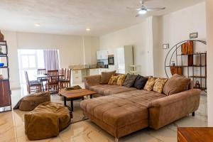 sala de estar con sofá marrón y cocina en Grecialandia, en San Felipe de Puerto Plata