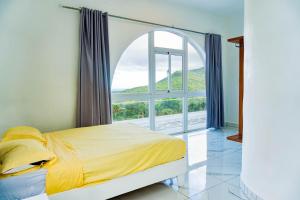 Un dormitorio con una cama y una ventana grande. en Grecialandia, en San Felipe de Puerto Plata 48 fotos más
