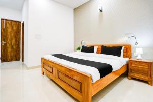 una camera da letto con un letto di legno in una stanza di Hotel O The Grand Blue Hotel a Noida