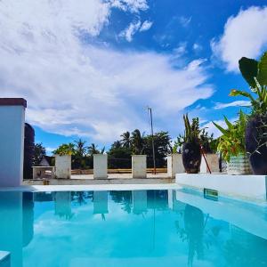 una piscina con acqua azzurra e palme di Luxury Penthouse with private rooftop pool prime location Paje Beach Zanzibar TV WIFI AC steps to the beach a Paje