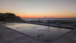 una piscina con un tramonto sullo sfondo di Hotel Piccolo Paradiso Del Gargano a Rodi Garganico