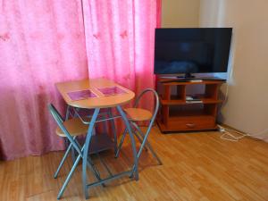 a small table and two chairs and a television at Apartman a Déliparton in Szántód