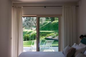 ein Schlafzimmer mit einem Bett und einer Glasschiebetür in der Unterkunft Podere Sabaina, Private Villa mit Pool, Seeblick und 3 Wohneinheiten zur Alleinnutzung in Torri del Benaco + 79 Fotos