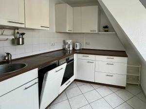 a kitchen with white cabinets and a sink at Ferienwohnung für 5 Personen in Dresden