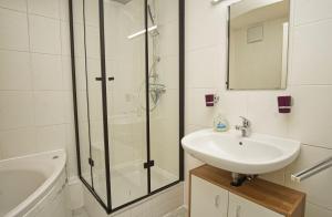 une salle de bain avec une douche, un lavabo et une baignoire dans l'établissement FeWo am Hochzeitsberg FeWo 17 - Souterrain, à Breege 28 autres photos