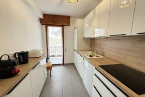a kitchen with white cabinets and wooden counter tops at Beautiful detached house facing the slopes in Valberg