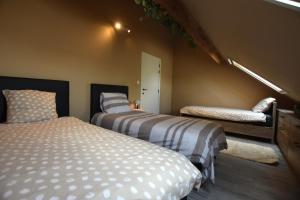 a bedroom with two beds and a bench in it at Gezellig en comfortabele studio vlakbij Gent in Evergem +5 photos