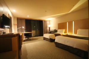 Postel nebo postele na pokoji v ubytování Ramada by Wyndham Songdo