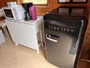 a refrigerator next to a microwave and a coffee maker at Klippertorp in Enköping