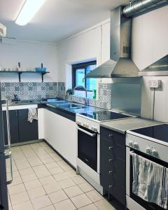 a large kitchen with a sink and a stove at Klippertorp in Enköping