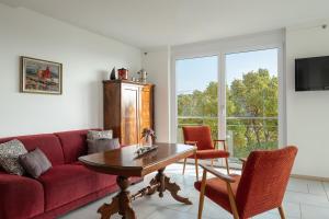 a living room with a red couch and a table at Ferienwohnung Ankerplatz in Überlingen