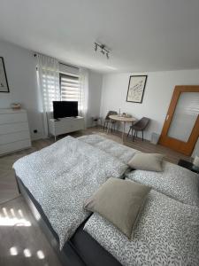 a bedroom with two beds and a table and a television at Apartment Anna in Inzigkofen