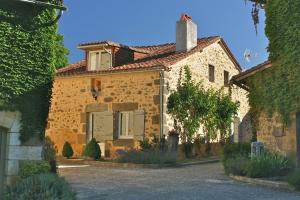 une grande maison en pierre avec une allée en face de celle-ci dans l'établissement Maison Lavande, à Saint-Martial-de-Valette