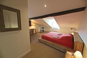 une chambre avec un lit rouge dans une pièce dans l'établissement Maison Lavande, à Saint-Martial-de-Valette 14 autres photos