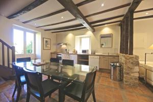 une salle à manger avec une table et une cuisine dans l'établissement Maison Lavande, à Saint-Martial-de-Valette