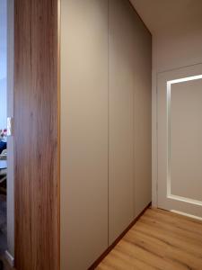 a room with a white wall and a wooden floor at Luxusowy Apartament Staszica in Koszalin