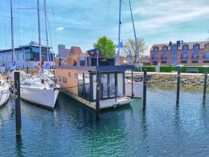 a boat docked at a dock in the water at Hausboot - Meeresbrise in Heiligenhafen