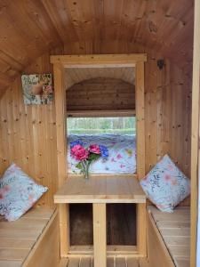 a wooden cabin with a window and a vase of flowers at Cozy Wooden Chalet in Abilly, France in Abilly-Sur-Claise