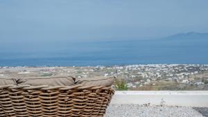 a basket sitting on a ledge with a view of a city at Ico Santorini in Pyrgos