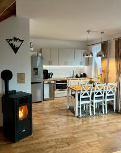 a kitchen with a stove and a table with chairs at Domki Odskocznia in Maniowy