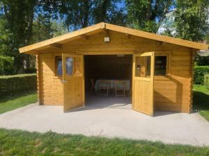 a wooden shed with a table in it at Small cosy Bluebell cabin in the French countryside in Abilly-Sur-Claise