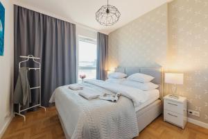 sypialnia z dużym łóżkiem i oknem w obiekcie P&O Apartments KONSTRUKTORSKA Mokotów w Warszawie
