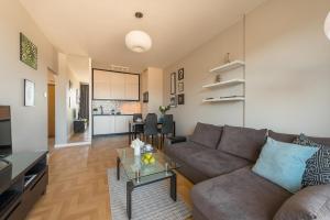 salon z kanapą i stołem w obiekcie P&O Apartments KONSTRUKTORSKA Mokotów w Warszawie +3 zdjęcia