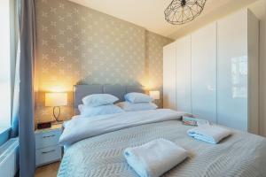 sypialnia z dużym łóżkiem i dwoma ręcznikami na nim w obiekcie P&O Apartments KONSTRUKTORSKA Mokotów w Warszawie