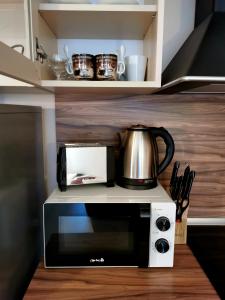 un horno microondas con cafetera encima en Студио Черноморски залив Атия Резорт, en Chernomorets 61 fotos más