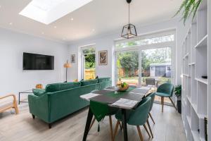 a living room with a green couch and a table at London 5 BR 3 Bathroom Garden Hse Near Metro and Hampstead Heath Sleeps 10 in London