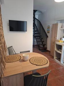 a dining room table with a television on a wall at FERMINA KaGa kythnosuites in Mérikhas