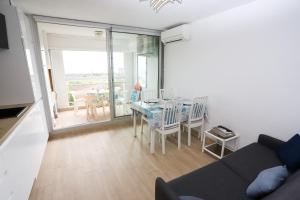 Una sala de estar con un sofá y una mesa con sillas. en Appart vue mer accès plage et piscine à 30m, en Saint-Cyprien