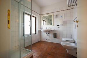 łazienka z 2 toaletami, umywalką i prysznicem w obiekcie Agriturismo Mulino Delle Tolle w mieście Bagnário Arsa +37 zdjęć