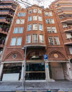 巴塞罗那Hotel Gran Derby Suites, a Small Luxury Hotel of the World的前面有停车标志的砖砌建筑