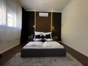 a bedroom with a bed with white sheets and pillows at Sion Residence in Debrecen