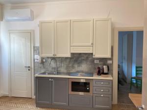 a kitchen with white cabinets and a sink at Aro's House in Cremona